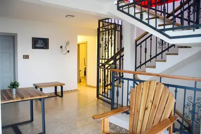 a room with a staircase and a wooden chair at Hostal Marina Samana in Santa Bárbara de Samaná