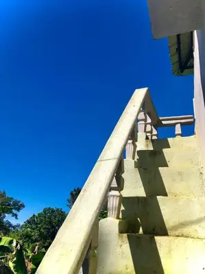 a stairway with a wooden railing and blue sky at Casa Linda - 10 mins from Beach & Lagoon with AC & Free Parking in Payita