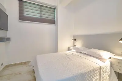 a white bedroom with a bed and a window at spectacular sea view in Santo Domingo
