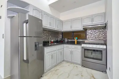 a kitchen with white cabinets and a stainless steel refrigerator at spectacular sea view in Santo Domingo