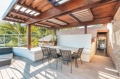 a patio with a table and chairs on a deck at Gorgeous PH at Puerto Bahia in Santa Bárbara de Samaná