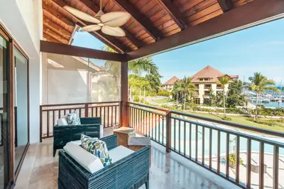 a balcony with two chairs and a ceiling fan at Gorgeous PH at Puerto Bahia in Santa Bárbara de Samaná