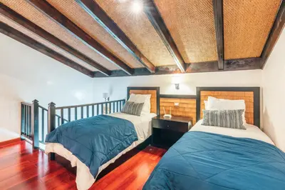 two beds in a room with wooden floors at Gorgeous PH at Puerto Bahia in Santa Bárbara de Samaná
