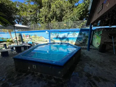 a large blue hot tub sitting next to a fence at Sana El Jardin Secreto in Santiago de los Caballeros