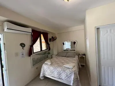 a small bedroom with a bed and a window at Sana El Jardin Secreto in Santiago de los Caballeros
