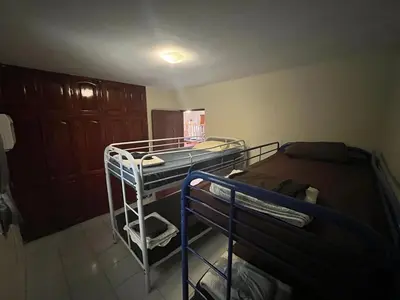 a room with two bunk beds and a cabinet at Sana El Jardin Secreto in Santiago de los Caballeros
