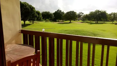 a view of a golf course from a balcony at Green Paradise in Juan Dolio