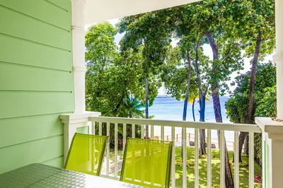 a porch with a table and chairs and the ocean at 