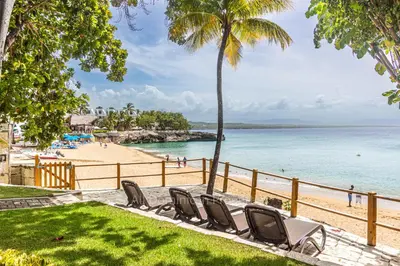 a beach with chairs and a fence and the ocean at 