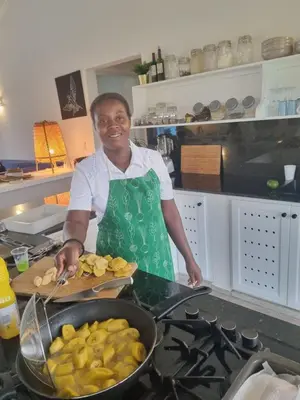 a woman standing in a kitchen preparing food at Finca Jasmat in Cabrera