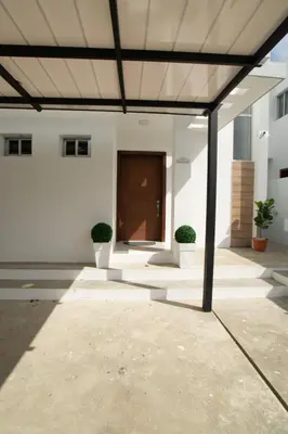 a large white building with a wooden door at Villa Golden Dream in San Felipe de Puerto Plata