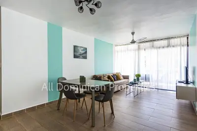a living room with a table and chairs and a couch at Monte Vista Apartments in Sosúa