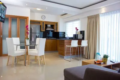 a kitchen with a glass table and white chairs at Modern and centric Apartment with pool and gym at Downtown in Santo Domingo