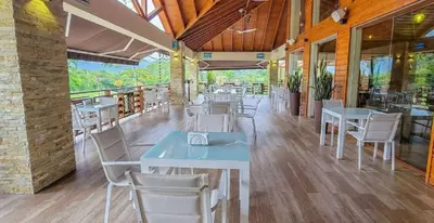 a restaurant with tables and chairs in a building at Vista del Campo Country Club & Villas in Jarabacoa