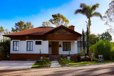a house with a palm tree in front of it at Vista del Campo Country Club & Villas in Jarabacoa