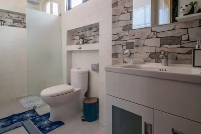 a bathroom with a white toilet and a sink at Loft con terraza en Santo Domingo in La Estrella