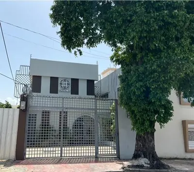 a gate with a tree in front of a building at Hostal 53 Boutique Santo Domingo in Santo Domingo