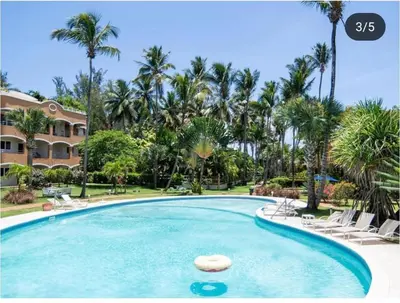 a swimming pool in a resort with palm trees at Apartamento con vista a la piscina in Las Terrenas