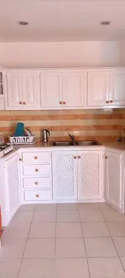 a kitchen with white cabinets and a sink at El Rinconcito Caribeño in La Laguna