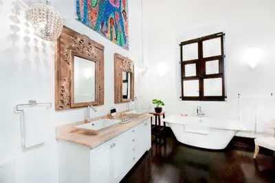 a bathroom with two sinks and a tub and a mirror at Casas del XVI in Santo Domingo