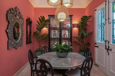 a dining room with red walls and a table and chairs at Casas del XVI in Santo Domingo