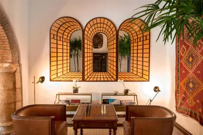 a room with a table and chairs and two mirrors at Casas del XVI in Santo Domingo