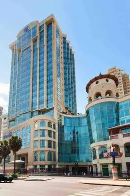 a large building with glass windows on a city street at Beach Front Penthouse in Exclusive Tower in Santo Domingo