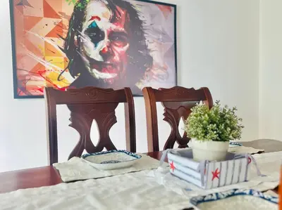 a table with two chairs and a painting of a clown at Beach Front Penthouse in Exclusive Tower in Santo Domingo