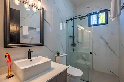 a bathroom with a sink and a glass shower at Sosua Ocean Village, Villa 9 Campo Del Mar , IV in Sosúa