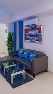 a living room with a brown couch and blue pillows at Simply the most comfortable place next to Boca Chica beach in Boca Chica