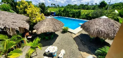 an image of a swimming pool with umbrellas at HOTEL RANCHO EL NOVATO in Concepción de La Vega