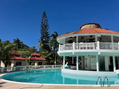 a large white house with a swimming pool at Palms Lounge Cabarete in Cabarete