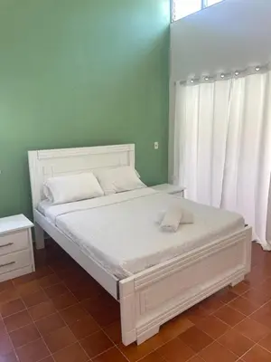 a bedroom with a white bed with white pillows at Palms Lounge Cabarete in Cabarete