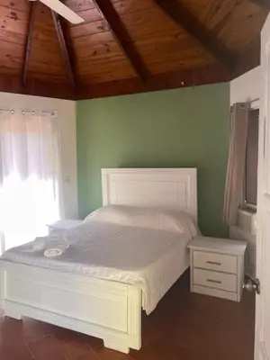 a bedroom with a white bed and a window at Palms Lounge Cabarete in Cabarete