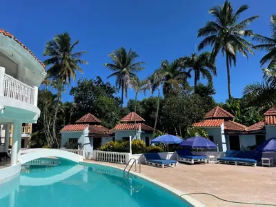 a pool at the resort with palm trees in the background at Palms Lounge Cabarete in Cabarete