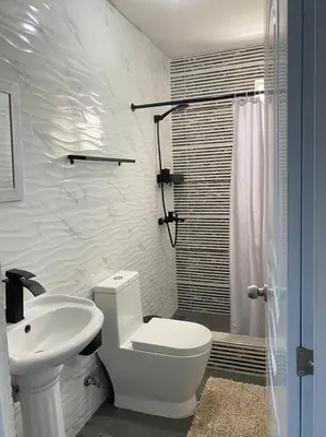 a white bathroom with a toilet and a sink at Tiny Apartment By Merengue House ,8 minutos airport in Santo Domingo
