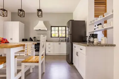 a kitchen with white cabinets and a black refrigerator at Villas Elim A and B in Cabrera