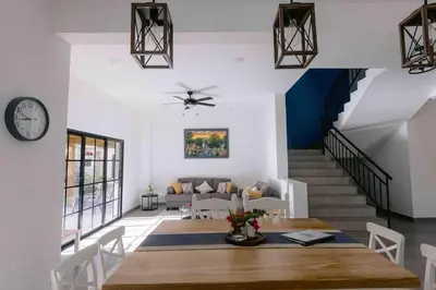 a dining room and living room with a table and a clock at Villas Elim A and B in Cabrera