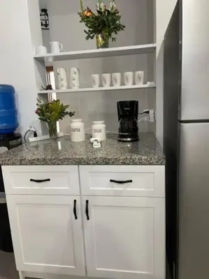 a kitchen counter with white cabinets and a refrigerator at Villas Elim A and B in Cabrera