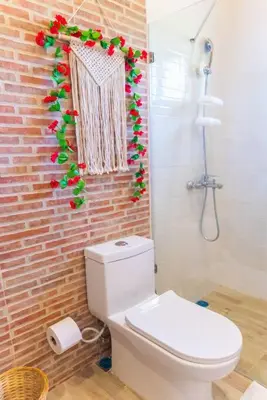 a bathroom with a toilet and a brick wall at Hacienda La Huerta, Puerto Plata in San Felipe de Puerto Plata