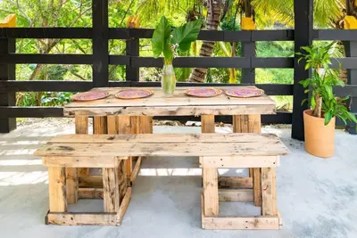 a wooden table and bench with plates on it at Hacienda La Huerta, Puerto Plata in San Felipe de Puerto Plata