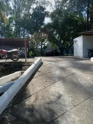 a concrete parking lot with a motorcycle parked in a driveway at Tropical Optimal Tropicana Sur in Sosúa