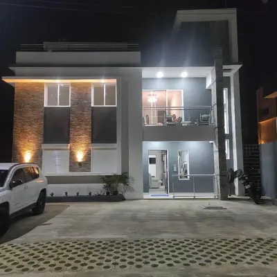 a white car parked in front of a house at night at Villa Vintage. in Boca Chica