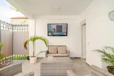 a living room with a couch and palm trees at Villa Vintage. in Boca Chica