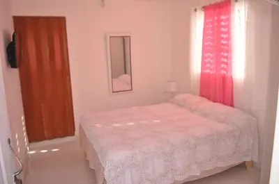 a small bedroom with a bed and a window at Residencial Lucy in Boca Chica