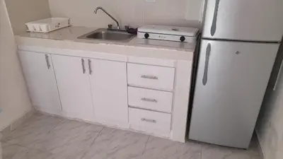 a white kitchen with a sink and a refrigerator at Residencial Lucy in Boca Chica