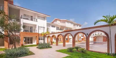 an apartment complex with an archway in a courtyard at Beauty Apartment Coral Village 2 close to the beach in Punta Cana