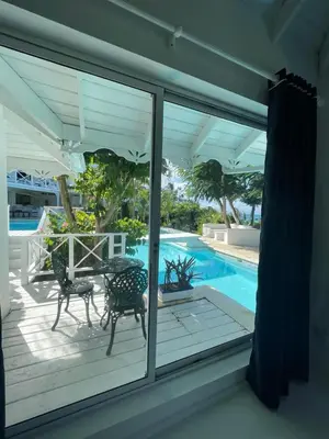 a patio with a table and chairs next to a swimming pool at ITAKA LOMA BONITA in Las Terrenas