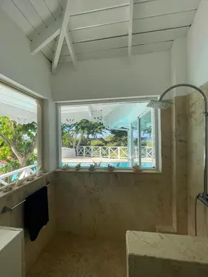 a bathroom with a shower and a window and a tub at ITAKA LOMA BONITA in Las Terrenas