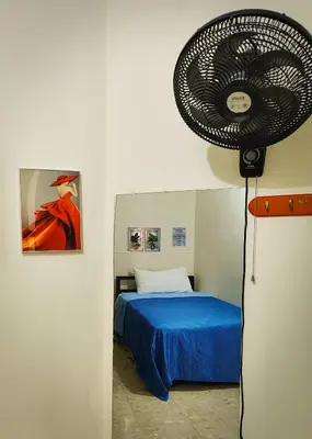 a bedroom with a fan next to a bed at Refugio Encantador in Santo Domingo